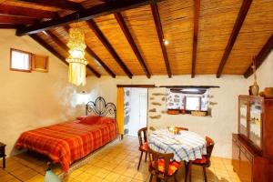 a bedroom with a bed and a table at Ferienhaus in El Risco mit Garten, Terrasse und Grill in Agaete