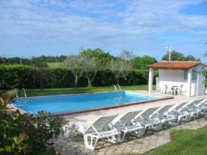 een rij ligstoelen naast een zwembad bij Bungalow mit Pool und Garten in Porec in Poreč