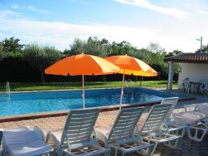 twee stoelen en parasols naast een zwembad bij Bungalow mit Pool und Garten in Porec in Poreč