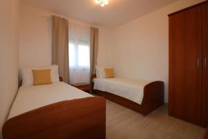 een hotelkamer met twee bedden en een raam bij Bungalow mit Pool und Garten in Porec in Poreč +14 foto's