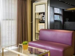 a living room with a purple couch and a table at Lavande Hotel Guangzhou Tianhe Park Metro Station in Guangzhou