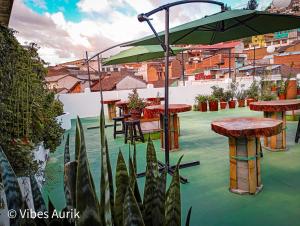 a patio with tables and chairs and an umbrella at Vibes Aurik in Quito