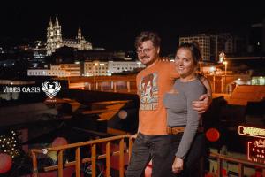 a man and woman standing on a balcony at night at Vibes Aurik in Quito