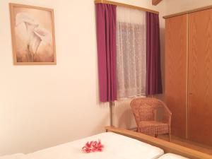 a bedroom with a bed and a chair and a window at Ferienwohnungen Stecher in Bad Endorf