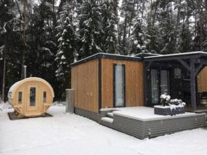 a cabin in the snow with snow covered trees at Nettes Ferienhaus in Wackersdorf mit Sauna, Grill und Whirlpool in Wackersdorf