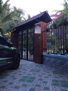a car parked in front of a gate at HÒANG HÔN HOMESTAY in Ben Tre