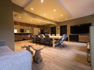 ein Esszimmer mit Tisch und Stühlen in der Unterkunft Chalet familial avec salle de jeux et spa, près de Gérardmer, pour 15 pers. - FR-1-589-647 in Ban-sur-Meurthe-Clefcy + 27 Fotos