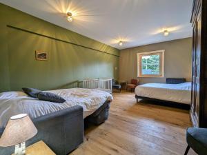 ein Schlafzimmer mit zwei Betten und einer Couch darin in der Unterkunft Chalet familial avec salle de jeux et spa, près de Gérardmer, pour 15 pers. - FR-1-589-647 in Ban-sur-Meurthe-Clefcy