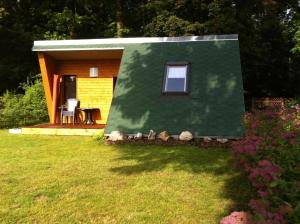 a small house with a green roof in a yard at Haus Waldesrauschen der Ferienanlage Rabenstein in Chemnitz