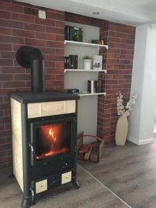 a wood stove in a room with a brick wall at Haus Waldesrauschen der Ferienanlage Rabenstein in Chemnitz +12 photos