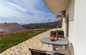 a table with a bowl of fruit on a patio at Lovely Apartment In Ribarica - Karlobag in Matić Podi