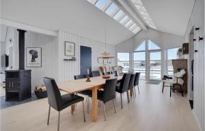 una sala da pranzo con tavolo in legno e sedie nere di Four-Bedroom Holiday Home In Tarm a Tarm