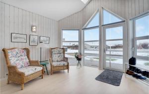 un soggiorno con due sedie e finestre di Four-Bedroom Holiday Home In Tarm a Tarm