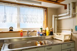 a kitchen with a sink and a window at Rishiri Antique Inn in Rishiri +126 photos