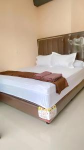 a bed with white sheets and pillows in a room at Diara Bungalow in Iboih +12 photos