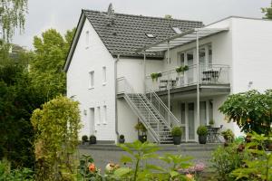 a white house with stairs and a balcony at Bed & Breakfast Meerbusch in Meerbusch