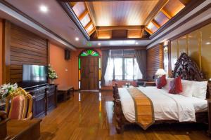 a bedroom with a large bed and a large window at Pingviman Hotel in Chiang Mai