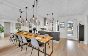Un comedor y una cocina con mesa y sillas. en Four-Bedroom Holiday Home In Ringkobing, en Ringkøbing