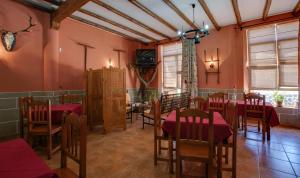 a dining room with red walls and wooden tables and chairs at Casa Rural La Breña in Talaván