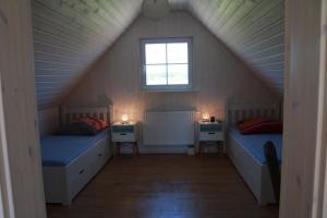 a attic room with two beds and a window at Gemütliches Ferienhaus in Zerpenschleuse mit Privater Terrasse in Wandlitz