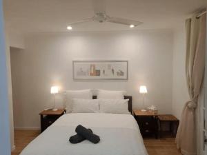 una camera da letto con un grande letto bianco con due lampade di private guest suite at sorrento a Gold Coast