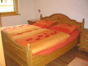 a bed with red flowers on it in a bedroom at Top gepflegtes Ferienhaus in ruhiger Lage, mit Balkon, Terrasse in Aschau im Chiemgau