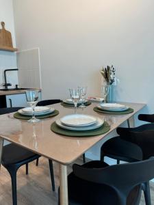 a wooden table with plates and wine glasses on it at A-Six Apartment luxury in Karagandy +21 photos