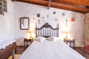 a bedroom with a bed and two tables with lamps at Casa do Professor in Casais dos Monizes