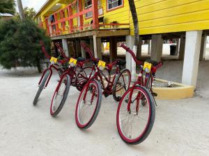 three red bikes parked in front of a building at Tropical Paradise Express in Caye Caulker