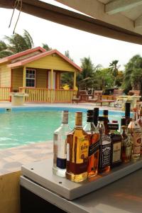 a table with bottles of alcohol sitting next to a swimming pool at Tropical Paradise Express in Caye Caulker
