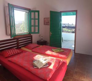 dwa łóżka w pokoju z drzwiami i dwoma oknami w obiekcie Finca mit Pool und herrlichem Meerblick w mieście Playa Blanca +14 zdjęć