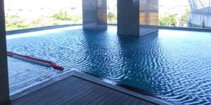 a pool of water with a red hose in a building at Nice and Comfortable Living 1BR at Grand Sungkono Lagoon Apartment By Travelio in Surabaya