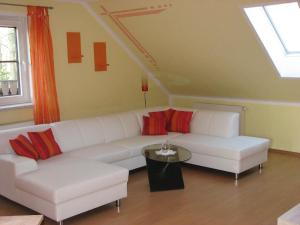 salon z białą kanapą i stołem w obiekcie Komfortable Ferienwohnung mit Balkon und Blick in den Schlosspark w mieście Elstra