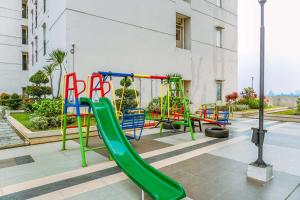 a playground with a green slide in a building at Simple and Cozy Living Studio Apartment at Margonda Residence 3 By Travelio in Depok