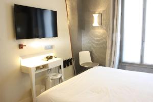 a bedroom with a bed and a tv on a wall at Le Malown in Paris