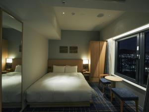 Postel nebo postele na pokoji v ubytování Hotel Traveltine Kyoto Kiyamachi