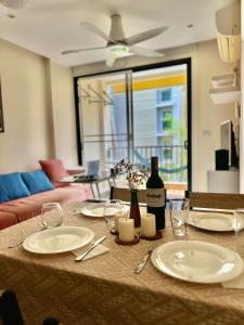 a table with plates and a bottle of wine on it at Appartement de 2 chambres à Naiharn Beach in Rawai Beach