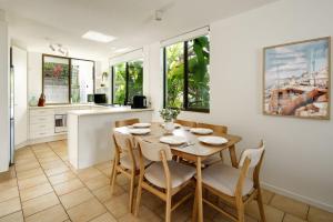 a kitchen and dining room with a table and chairs at Four Pines Shelly Beach Retreat in Caloundra