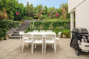 a white table and chairs and a grill on a patio at Four Pines Shelly Beach Retreat in Caloundra