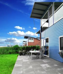 a patio with a table and chairs next to a house at Ferienhaus Jasmijn mit Garten und Terrasse in Anjum