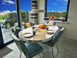 a dining room with a table and chairs and a large window at Ferienhaus Jasmijn mit Garten und Terrasse in Anjum