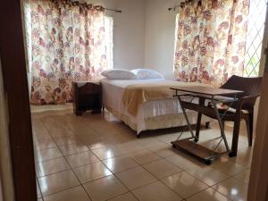 a bedroom with a bed and a table and curtains at Mountain View Escape in Mandeville