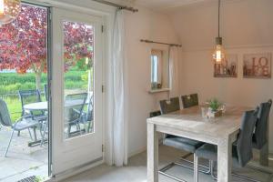 a dining room with a wooden table and chairs at Ferienhaus Lillian mit großer Terrasse in Anjum
