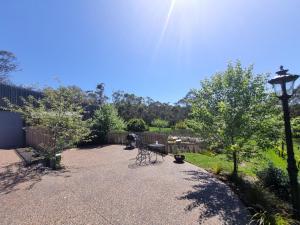 a patio with two benches and a street light at Winemakers Cottage at Treetops Red Hill in Red Hill