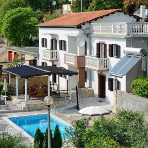 a villa with a swimming pool in front of a house at Ferienhaus 'Villa Ivisa' mit eigenem Pool in Rabac