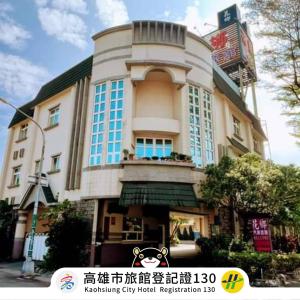 a large building with blue windows on a street at Hua Xiang Motel - Fengshan in Kaohsiung
