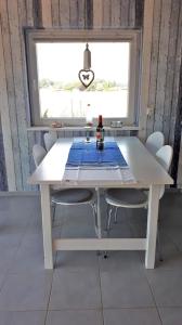 une table blanche avec des chaises dans une chambre avec une fenêtre dans l'établissement Ferienhaus mit Grill und Garten in Neukirchen, à Neukirchen 13 autres photos