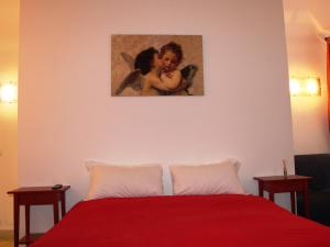 a bedroom with a red bed with a painting on the wall at Roman Forum Holiday Fori in Rome