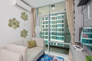 a living room with a couch and a large window at Azura by Kozystay - Alam Sutera in South Tangerang