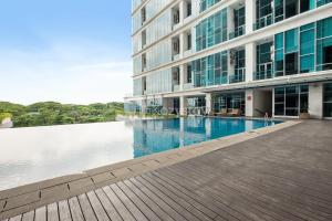 a large building with a swimming pool in front of it at Azura by Kozystay - Alam Sutera in South Tangerang